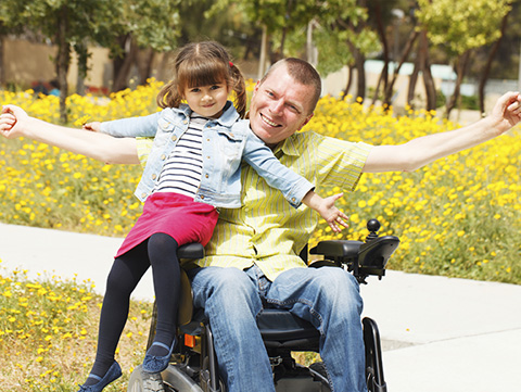 Dad in wheelchair playing with daughter