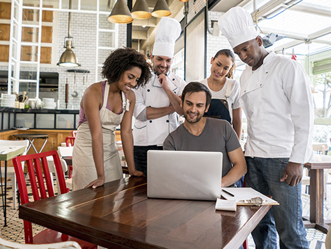 Waitress, business owner and chef look over menu selections for a busy restaurant