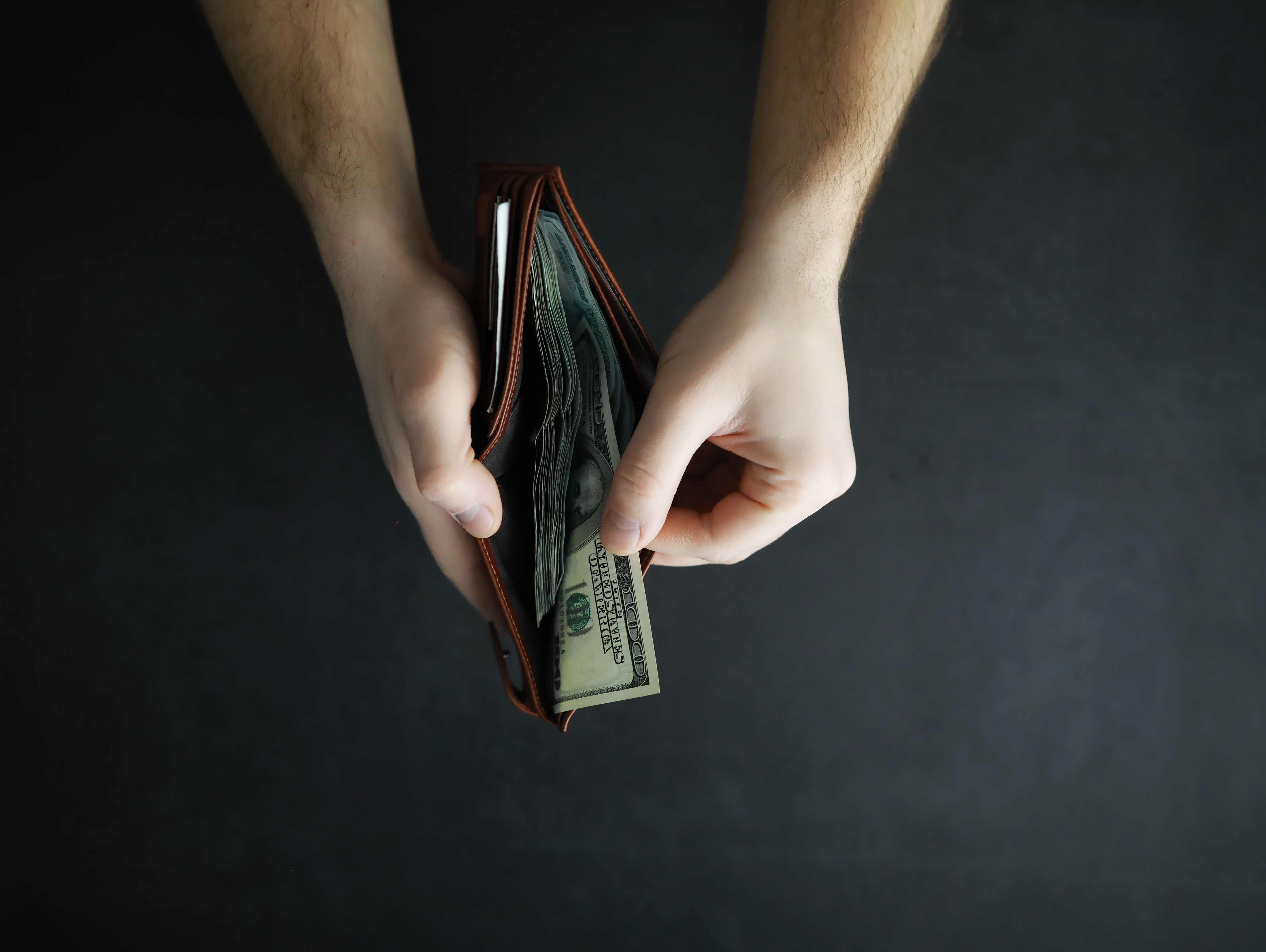 Close up of person holding wallet with cash