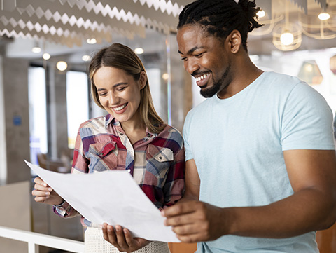 Man, woman standing, reviewing document