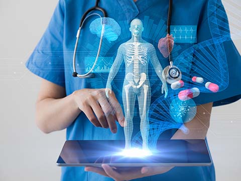 Person wearing scrubs holding tablet with skeletal image projecting from it