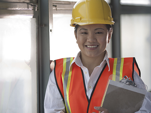 Female construction worker wearing hard hat, reflective vest