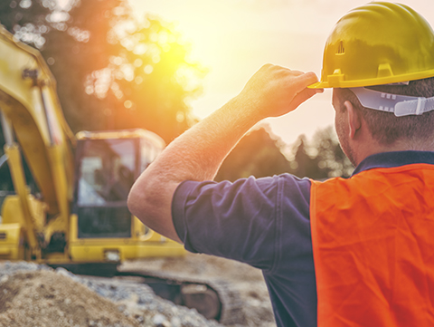 Construction worker on job site watching excavation